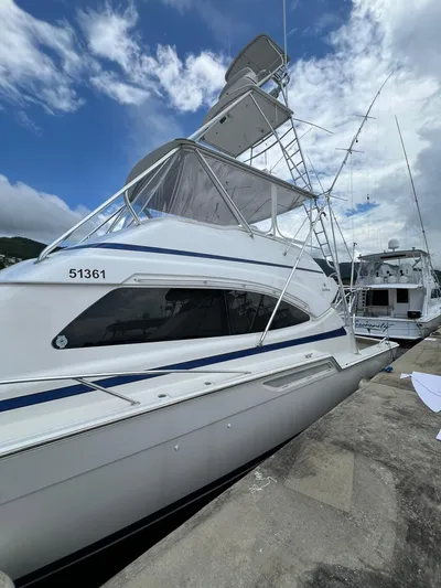 Play Pen Yacht Photos Pics 2001 Bertram 510 Convertible yacht docked under a partly cloudy sky.