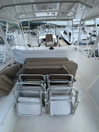 Play Pen Yacht Photos Pics 2001 Bertram 510 Convertible yacht with stacked chairs on deck, docked at marina.