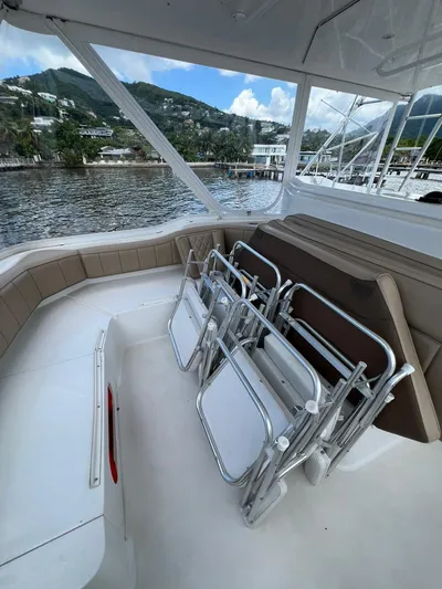 Play Pen Yacht Photos Pics 2001 Bertram 510 Convertible yacht interior with folded chairs, scenic waterfront view.