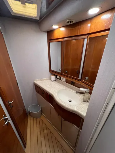 Play Pen Yacht Photos Pics 2001 Bertram 510 Convertible yacht bathroom with wooden cabinetry and modern fixtures.