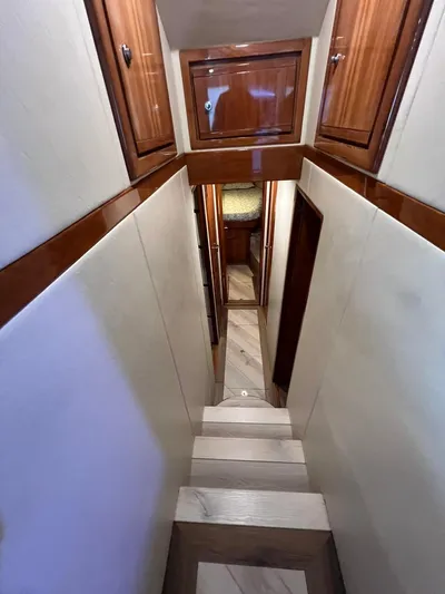 Play Pen Yacht Photos Pics Interior hallway of 2001 Bertram 510 Convertible yacht with wooden cabinets and stairs.
