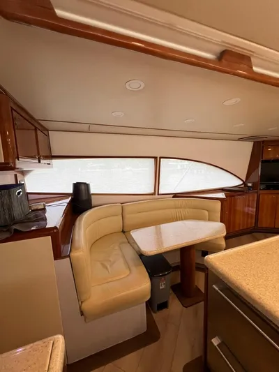 Play Pen Yacht Photos Pics Interior of a 2001 Bertram 510 Convertible yacht with beige seating and wooden accents.