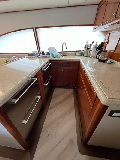 Play Pen Yacht Photos Pics Kitchen area of a 2001 Bertram 510 Convertible yacht with modern appliances and wood cabinetry.