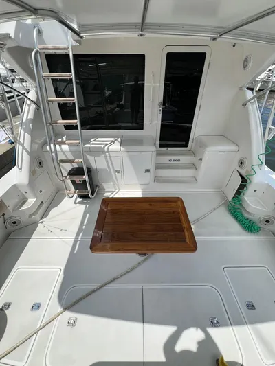 Play Pen Yacht Photos Pics 2001 Bertram 510 Convertible yacht deck with ladder and wooden table.