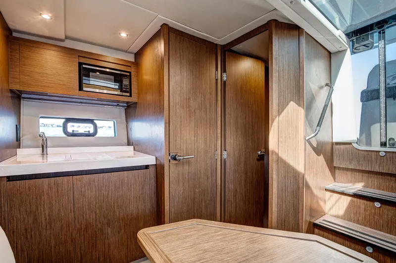  Yacht Photos Pics Interior of 2021 Beneteau Gran Turismo 36 yacht with wooden cabinetry and modern amenities.
