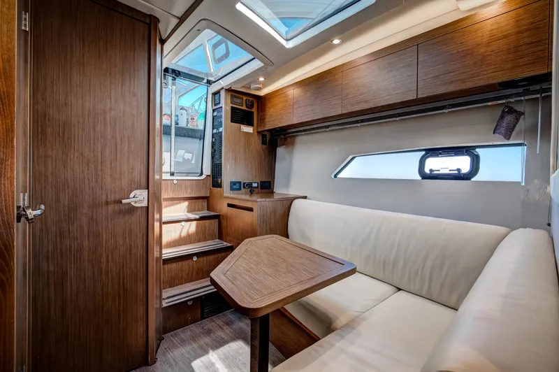  Yacht Photos Pics Interior of 2021 Beneteau Gran Turismo 36 yacht with wooden finishes and white seating.