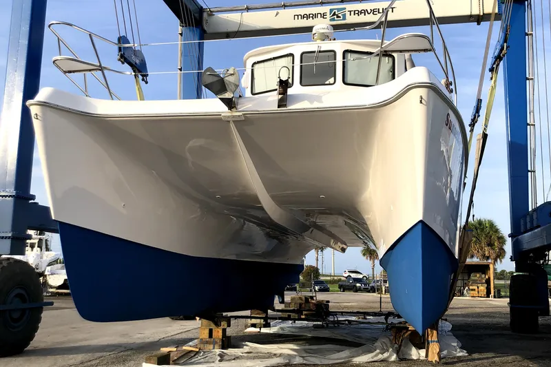 Sunset Cay Yacht Photos Pics 2004 Endeavour Explorer 46 PowerCat on lift, showcasing sleek design and blue hull.
