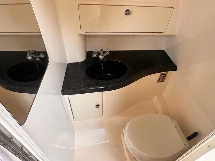  Yacht Photos Pics 2005 Boston Whaler 305 Conquest bathroom with sink, mirror, and toilet.