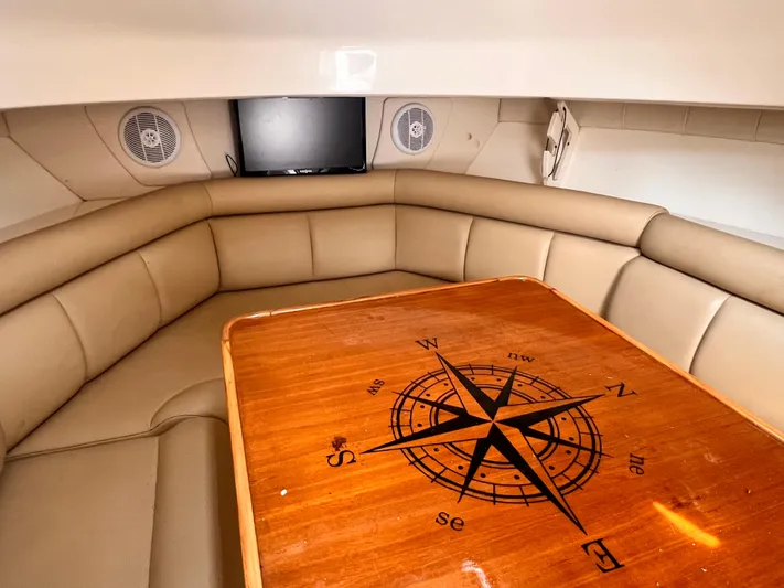  Yacht Photos Pics Interior of 2005 Boston Whaler 305 Conquest with compass rose table and beige seating.