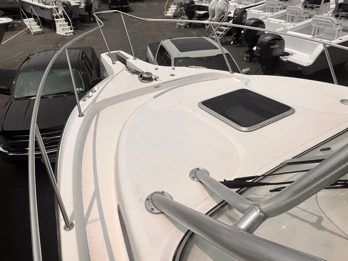  Yacht Photos Pics 2005 Boston Whaler 305 Conquest boat deck with railing and hatch, parked near vehicles.