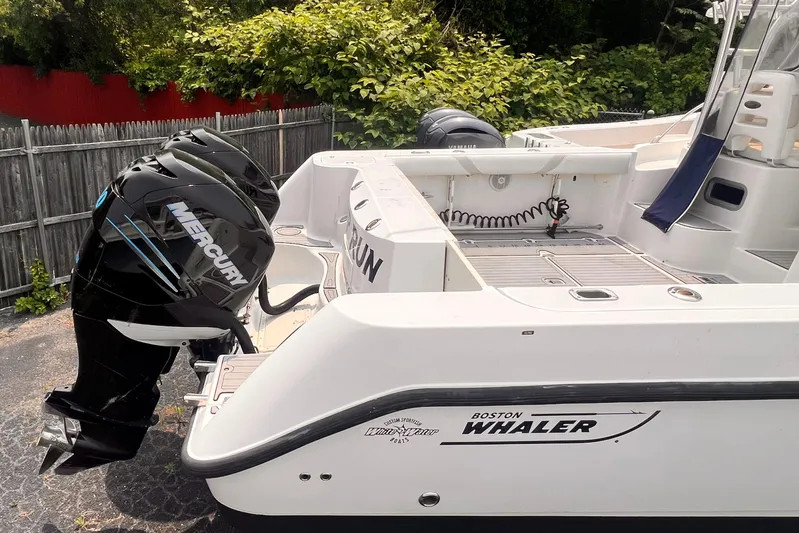  Yacht Photos Pics 2005 Boston Whaler 305 Conquest boat with Mercury outboard engines, docked outdoors.