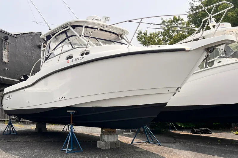 Yacht Photos Pics 2005 Boston Whaler 305 Conquest boat on stands, side view, outdoors.