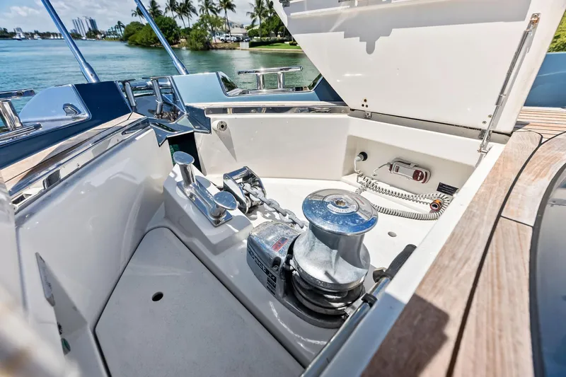 Momentum Yacht Photos Pics 2024 Riva 76 PERSEO Super yacht anchor compartment with winch and chain, docked by tropical shoreline.