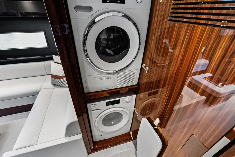 Momentum Yacht Photos Pics Laundry area inside 2024 Riva 76 PERSEO Super yacht with modern appliances and wood paneling.