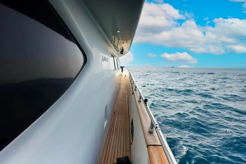 Lady A Yacht Photos Pics Side view of a 2000 Maiora 29 DP yacht cruising on the ocean under a blue sky.