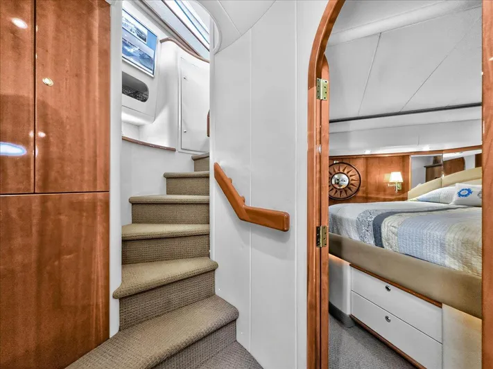 Vortex Yacht Photos Pics Interior of 2004 Neptunus 56 Flybridge yacht, featuring stairs and a cozy bedroom.