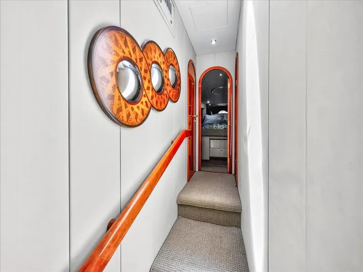 Vortex Yacht Photos Pics Hallway inside 2004 Neptunus 56 Flybridge yacht with decorative wall art and carpeted floor.