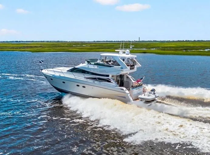 Vortex Yacht Photos Pics 2004 Neptunus 56 Flybridge yacht cruising on open water, creating a dynamic wake.