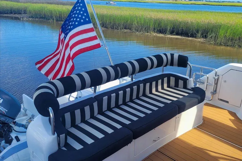 Vortex Yacht Photos Pics Luxurious 2004 Neptunus 56 Flybridge yacht with striped seating and American flag.
