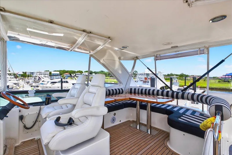 Vortex Yacht Photos Pics Luxurious 2004 Neptunus 56 Flybridge yacht interior with plush seating and scenic marina view.