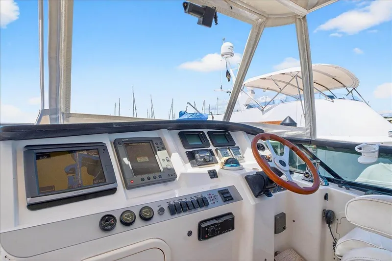 Vortex Yacht Photos Pics 2004 Neptunus 56 Flybridge helm with navigation equipment and wooden steering wheel.
