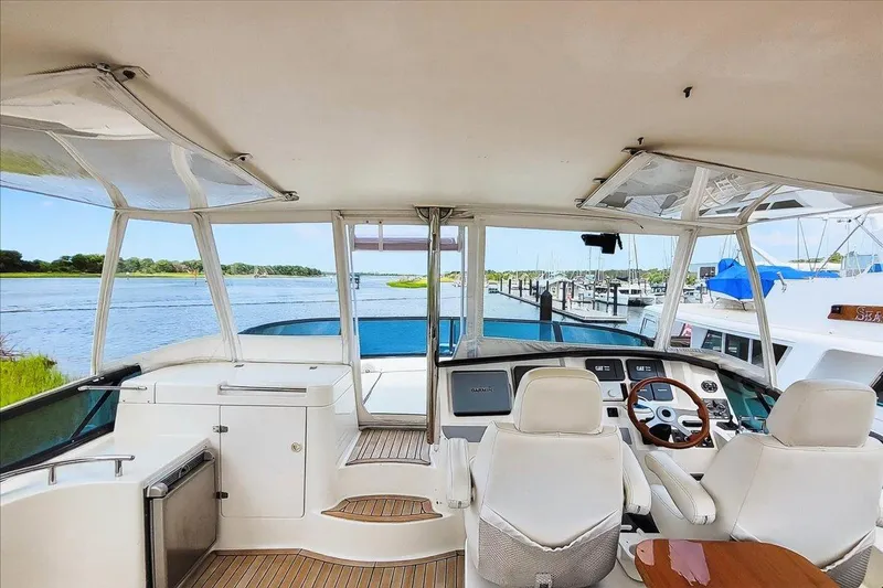 Vortex Yacht Photos Pics 2004 Neptunus 56 Flybridge yacht interior with helm, overlooking serene marina view.