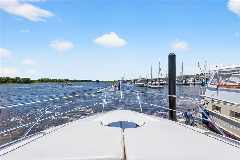 Vortex Yacht Photos Pics Bow view from 2004 Neptunus 56 Flybridge yacht in a marina, clear sky.