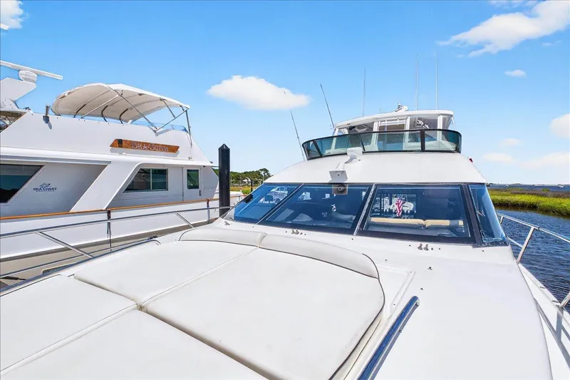 Vortex Yacht Photos Pics 2004 Neptunus 56 Flybridge yacht docked beside another vessel under a clear blue sky.