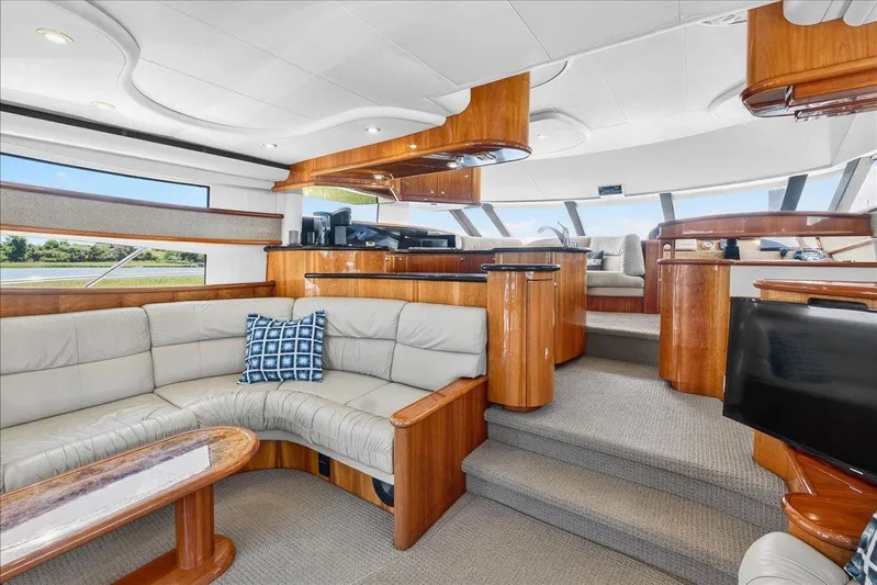 Vortex Yacht Photos Pics Luxurious interior of 2004 Neptunus 56 Flybridge yacht with elegant wood finishes and plush seating.