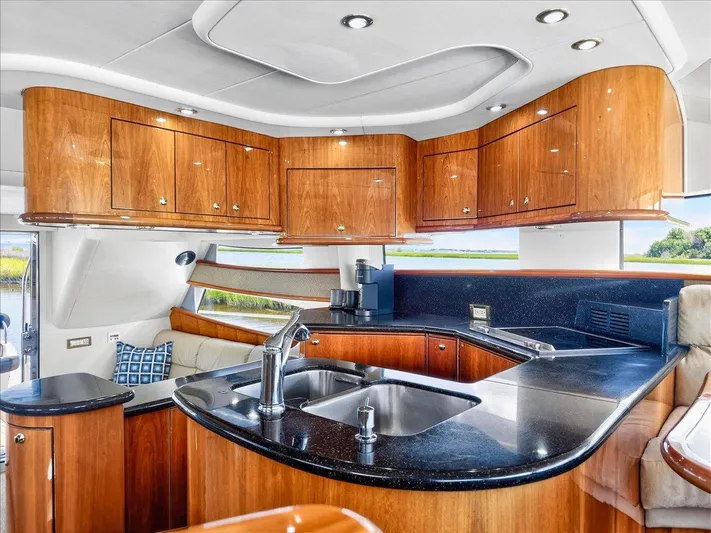 Vortex Yacht Photos Pics Luxurious 2004 Neptunus 56 Flybridge yacht interior with sleek kitchen and wooden cabinetry.
