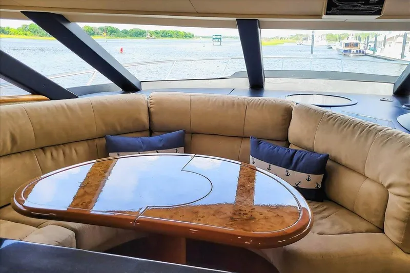 Vortex Yacht Photos Pics Luxurious interior of 2004 Neptunus 56 Flybridge yacht with plush seating and polished table.