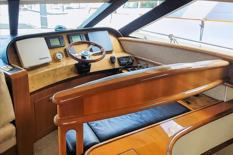 Vortex Yacht Photos Pics Luxurious 2004 Neptunus 56 Flybridge yacht helm with polished wood and modern navigation instruments.