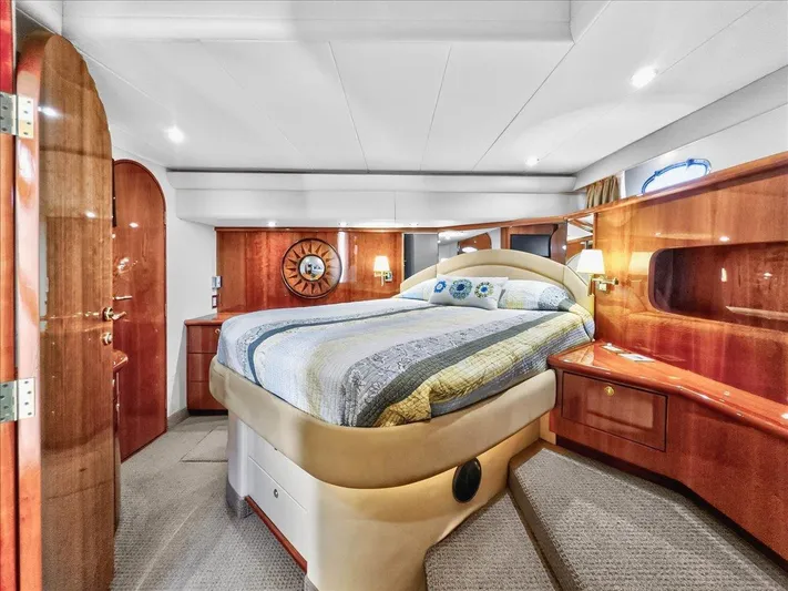 Vortex Yacht Photos Pics Luxurious 2004 Neptunus 56 Flybridge yacht bedroom with elegant wood finishes and cozy bedding.