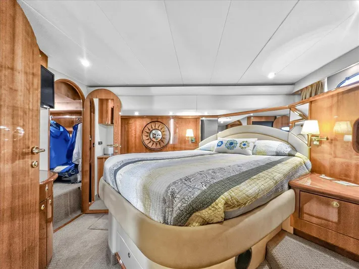Vortex Yacht Photos Pics Luxurious 2004 Neptunus 56 Flybridge yacht bedroom with elegant wood finishes and cozy bedding.