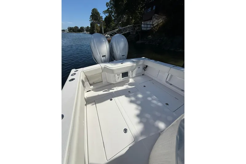  Yacht Photos Pics 2021 Jupiter 38 HFS boat deck with dual outboard motors, docked by a scenic waterfront.