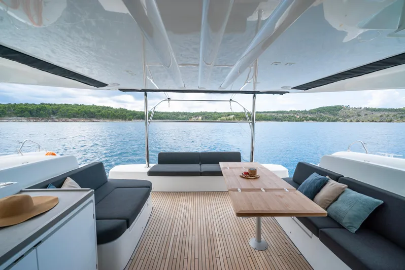 Spellbound Yacht Photos Pics 2023 Lagoon 50 catamaran deck with seating, table, and ocean view.
