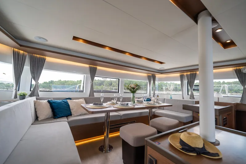 Spellbound Yacht Photos Pics Luxurious interior of 2023 Lagoon 50 yacht with elegant dining setup and panoramic windows.