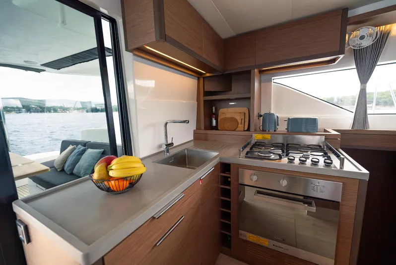 Spellbound Yacht Photos Pics Modern kitchen interior on 2023 Lagoon 50 yacht with fruit bowl and ocean view.