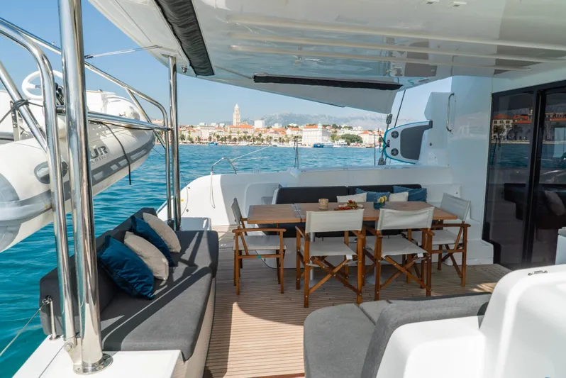 Spellbound Yacht Photos Pics Luxurious Lagoon 50 yacht deck with seating, dining area, and scenic ocean view, 2023 model.