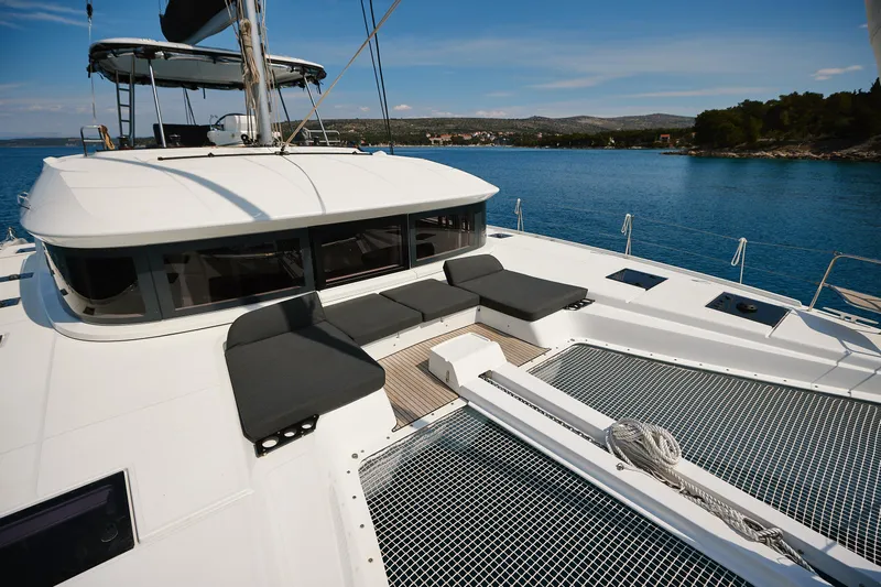 Spellbound Yacht Photos Pics 2023 Lagoon 50 catamaran with spacious deck and seating, anchored in serene blue waters.