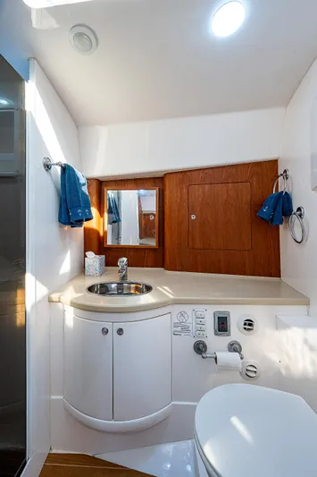 Annie Yacht Photos Pics Luxurious bathroom in 2014 Intrepid 475 Sport Yacht with modern fixtures and wood accents.