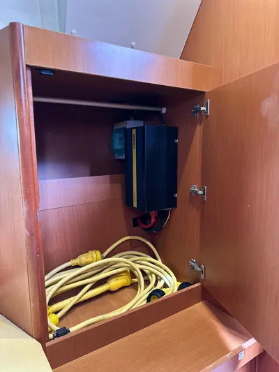 Sadalbari Yacht Photos Pics Cabinet interior of 2018 Beneteau Oceanis 41.1 with electrical components and yellow cables.