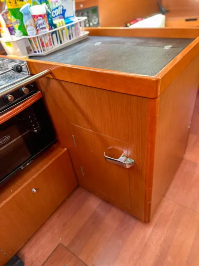 Sadalbari Yacht Photos Pics Galley area of 2018 Beneteau Oceanis 41.1 with wooden cabinetry and stove.