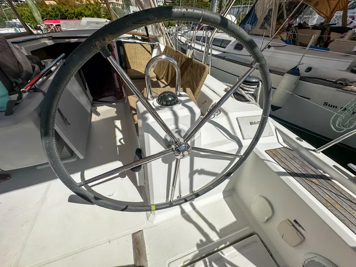 Sadalbari Yacht Photos Pics Steering wheel of a 2018 Beneteau Oceanis 41.1 sailboat, docked in a marina.