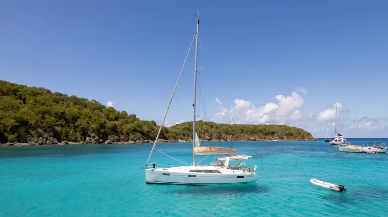 Sadalbari Yacht Photos Pics 2018 Beneteau Oceanis 41.1 sailboat anchored in turquoise waters, lush island backdrop.