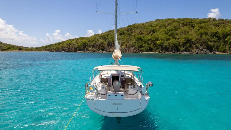 Sadalbari Yacht Photos Pics 2018 Beneteau Oceanis 41.1 sailboat anchored in clear turquoise water near lush green island.