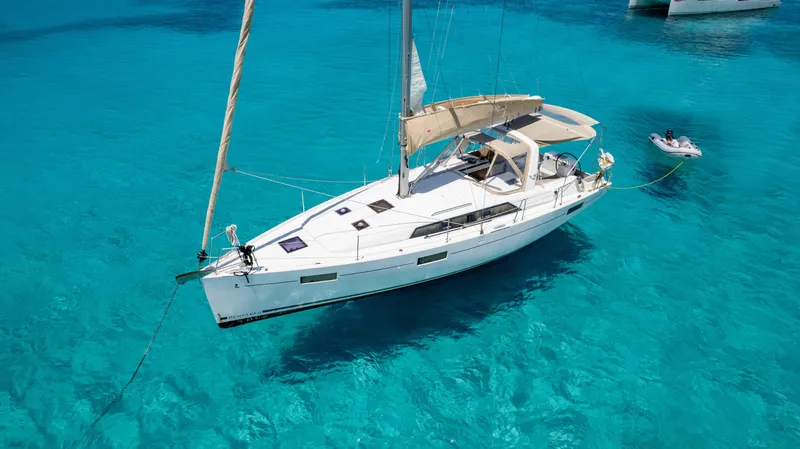 Sadalbari Yacht Photos Pics 2018 Beneteau Oceanis 41.1 sailboat on clear turquoise water, with a small dinghy nearby.