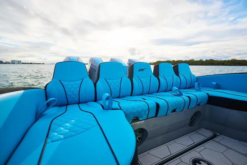 Yacht Photos Pics 2024 Midnight Express 37' Open boat with vibrant blue seating on a calm water backdrop.