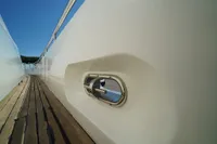 Side view of Custom HARD TOP 78 yacht under construction, featuring sleek white design and wooden deck.