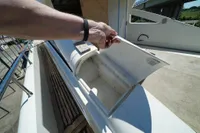A person opens a compartment on a Custom HARD TOP 78 yacht under construction.